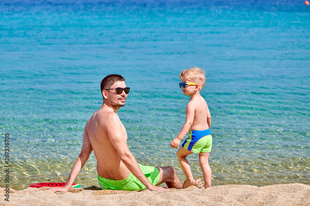 Naklejka premium Toddler boy on beach with father