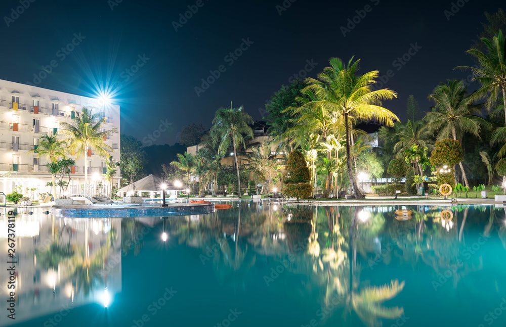 Landscape view of a Hotel resort during night with slow shutter smooth swimming water and nice starry lights