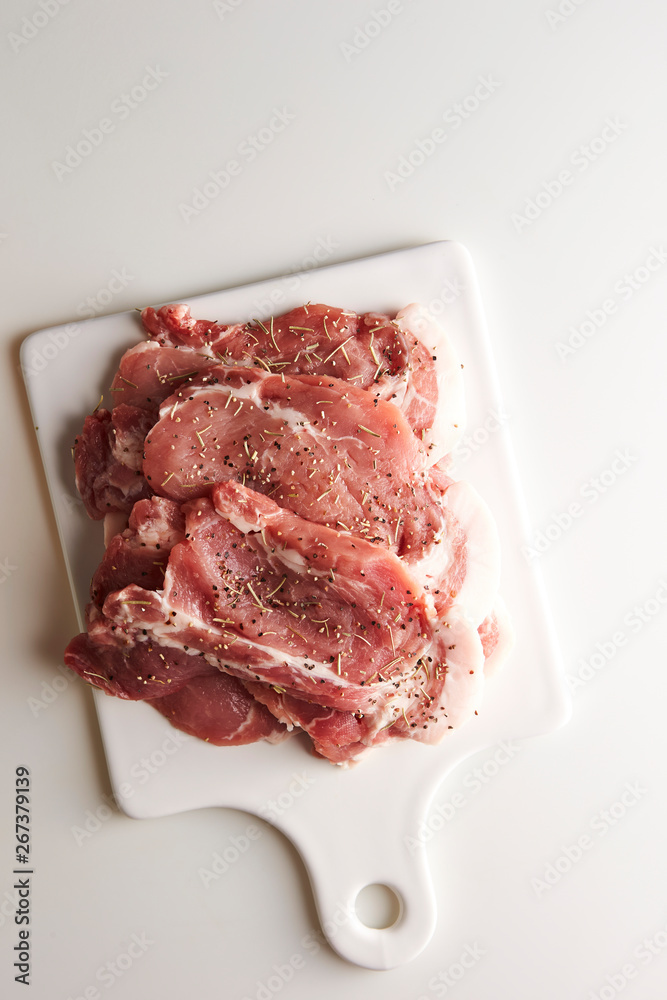 Fresh raw seasoned pork on cutting board 