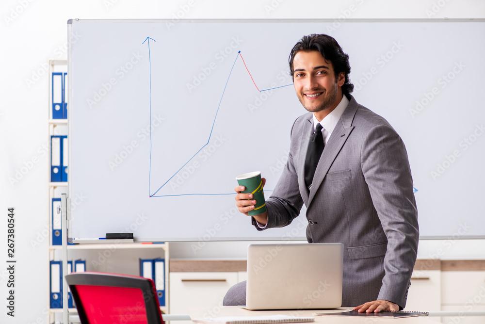 Naklejka premium Young handsome businessman in front of whiteboard 