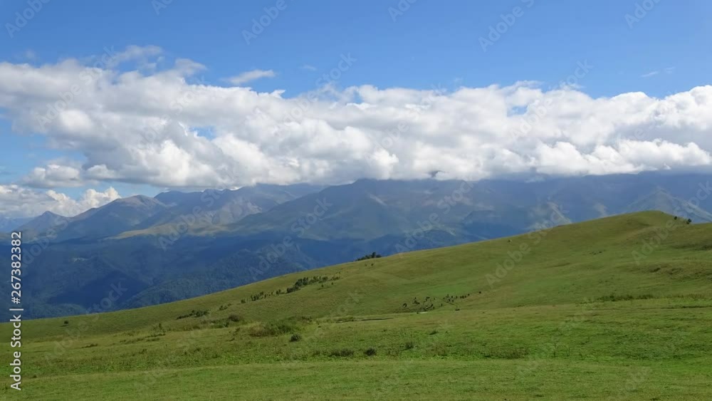 Time lapse mountains scene in national park of Dombay, Caucasus, Russia, Europe. Summer landscape, sunshine weather, blue sky and sunny day