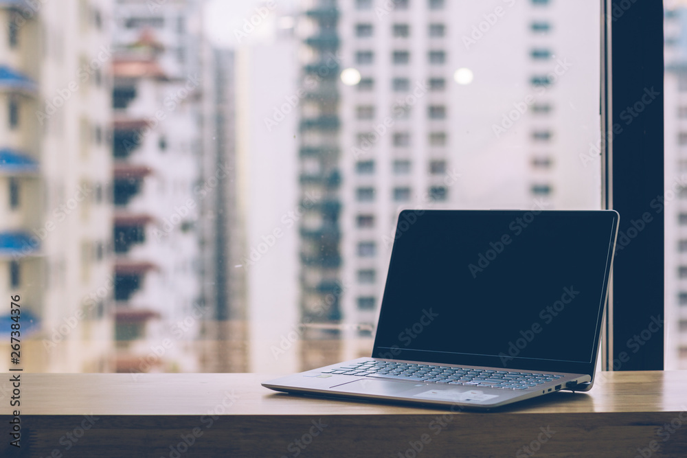 Laptop computer on counter near Glass windows of office building Laptop computer on counter near Glass windows of office building