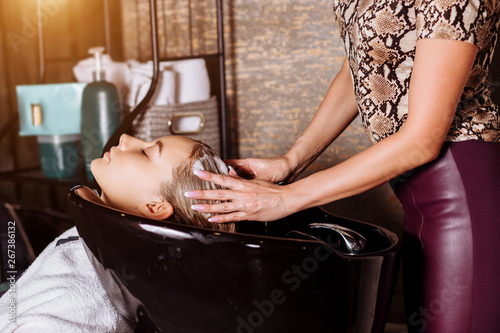 Beautiful woman washing hair in a hair salon