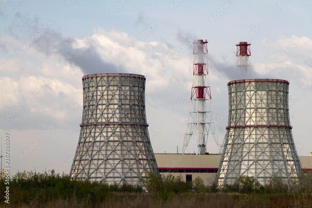 Thermal power station. Smoke from the pipes. Sunny day, blue sky background. Thermal power station. Smoke from the pipes. Sunny day, blue sky background.
