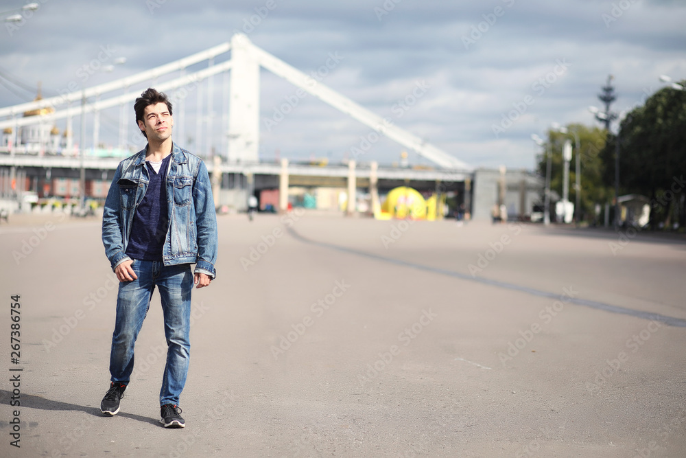 A young man walks in the park at lunch time. A man is on a walk in the city. A student in the park. A young man walks in the park at lunch time. A man is on a walk in the city. A student in the park.