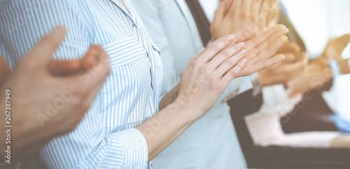 Business people clapping and applause at meeting or conference  close-up of hands. Group of unknown businessmen and women in modern white office. Success teamwork or corporate coaching concept