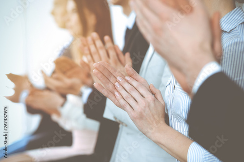 Business people clapping and applause at meeting or conference, close-up of hands. Group of unknown businessmen and women in modern white office. Success teamwork or corporate coaching concept
