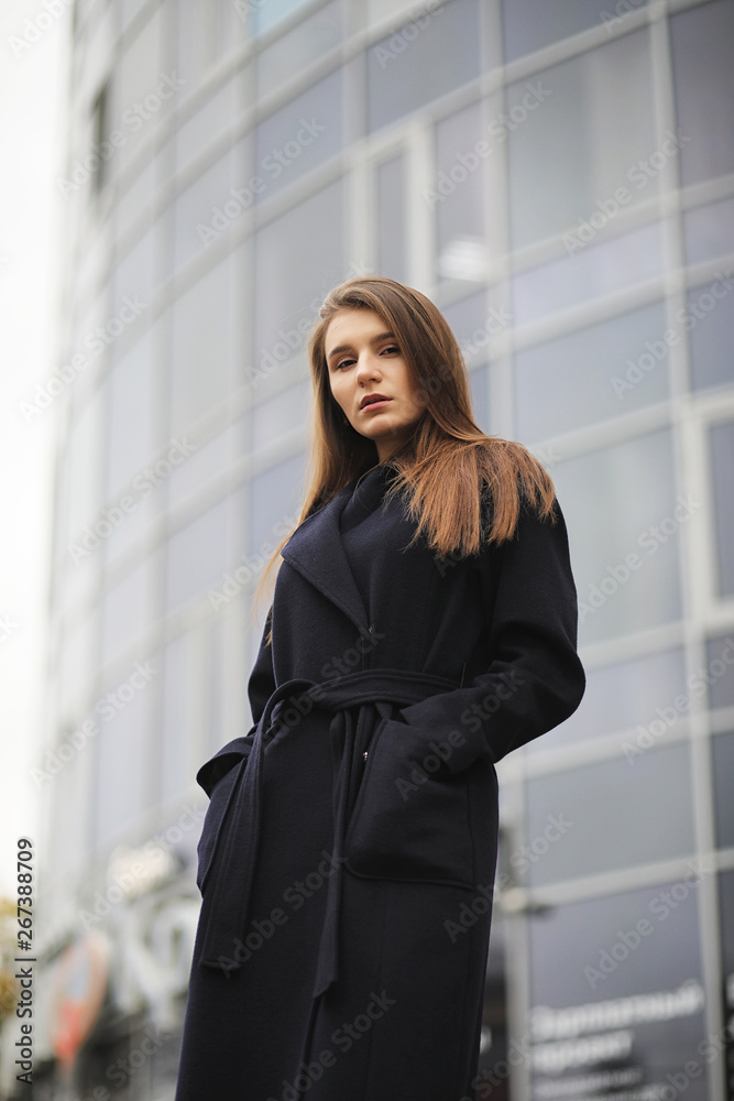 Beautiful girl in a coat in business downtown