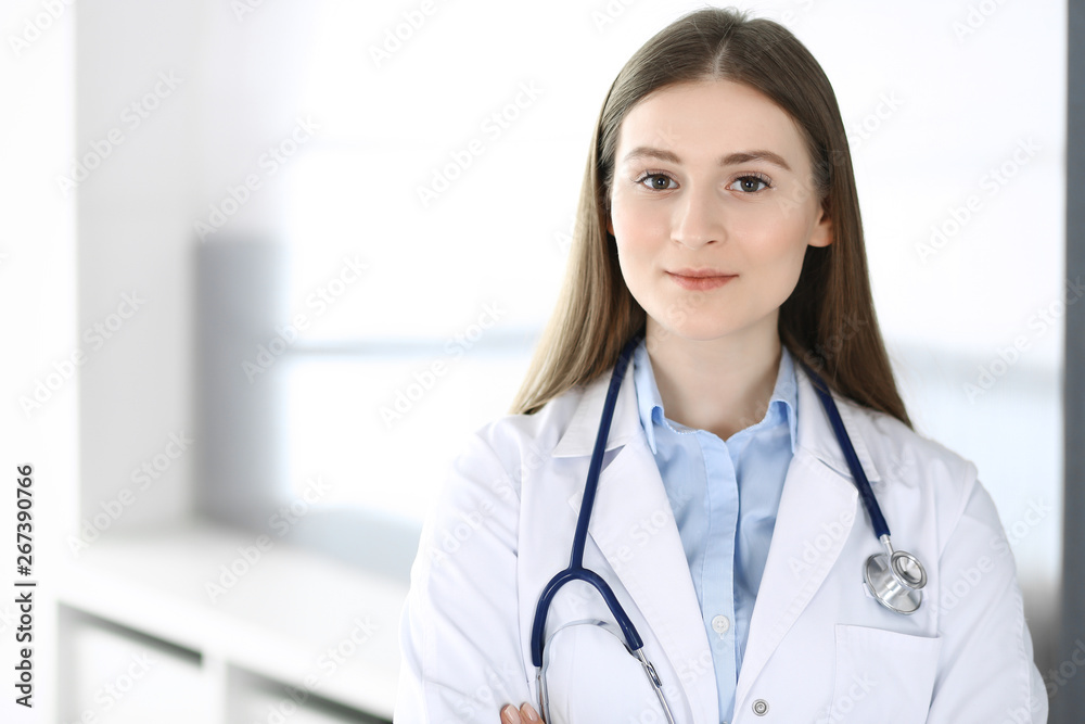Doctor woman standing straight with arms crossed, portrait. Perfect medical service in clinic. Medicine and healthcare concepts Doctor woman standing straight with arms crossed, portrait. Perfect medical service in clinic. Medicine and healthcare concepts