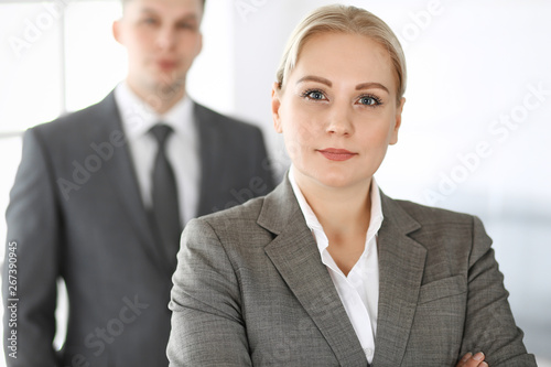 Business woman standing straight with colleague businessman in office, headshot. Success and corporate partnership concept