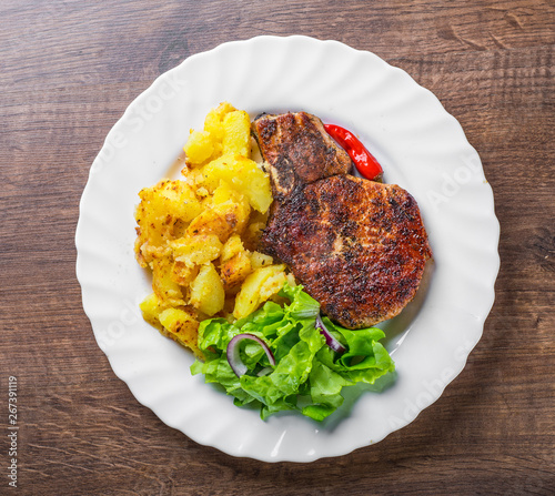 Pork Loin chops marinated meat Steak with vegetables slad and potato on wooden table background