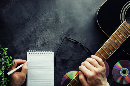 Guitar and accessories on a stone background. Desk musician, headphones, microphone. photo