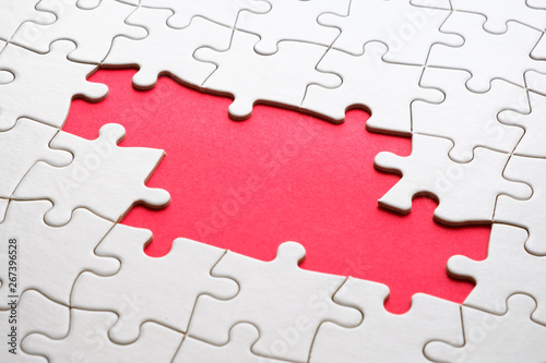 White jigsaw puzzle game pieces on red background form a banner for business theme design