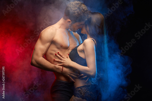 young hot people having intimate contact in the smoky studio. close up photo
