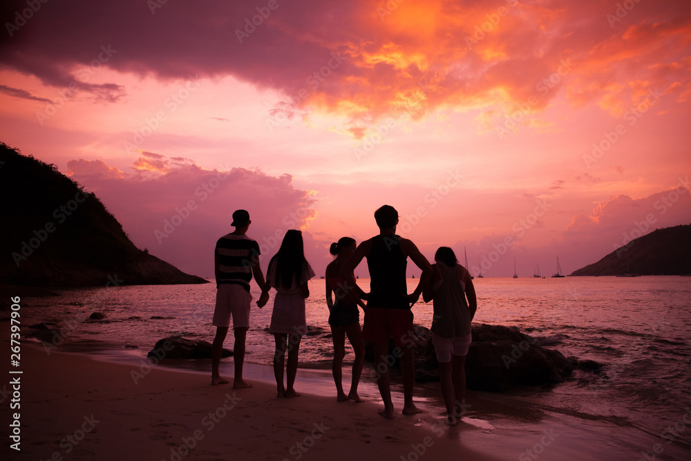 Friends on beach at sunset