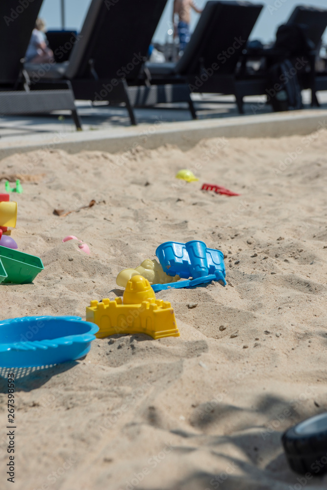 Colourful plastic toys with various shapes and kinds left unattended on a sand box in a resort, waiting for kids to come and enjoy them in a morning. Colourful plastic toys with various shapes and kinds left unattended on a sand box in a resort, waiting for kids to come and enjoy them in a morning.