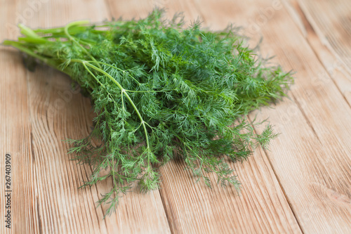 Fresh green organic dill on a wooden background.