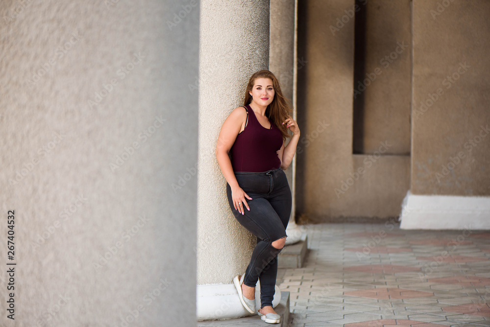 Young stylish woman walking on the city street in summer. Plus size model. Young stylish woman walking on the city street in summer. Plus size model.