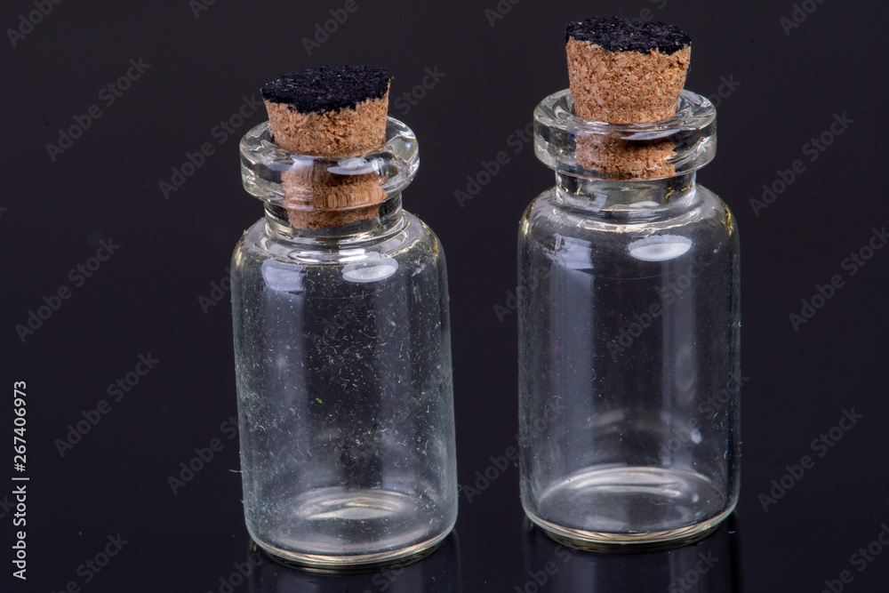 empty small glass bottles with a cork closure on a black background with text space empty small glass bottles with a cork closure on a black background with text space