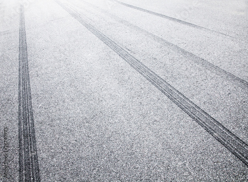 Wheel tracks on the road covered with hoarfrost