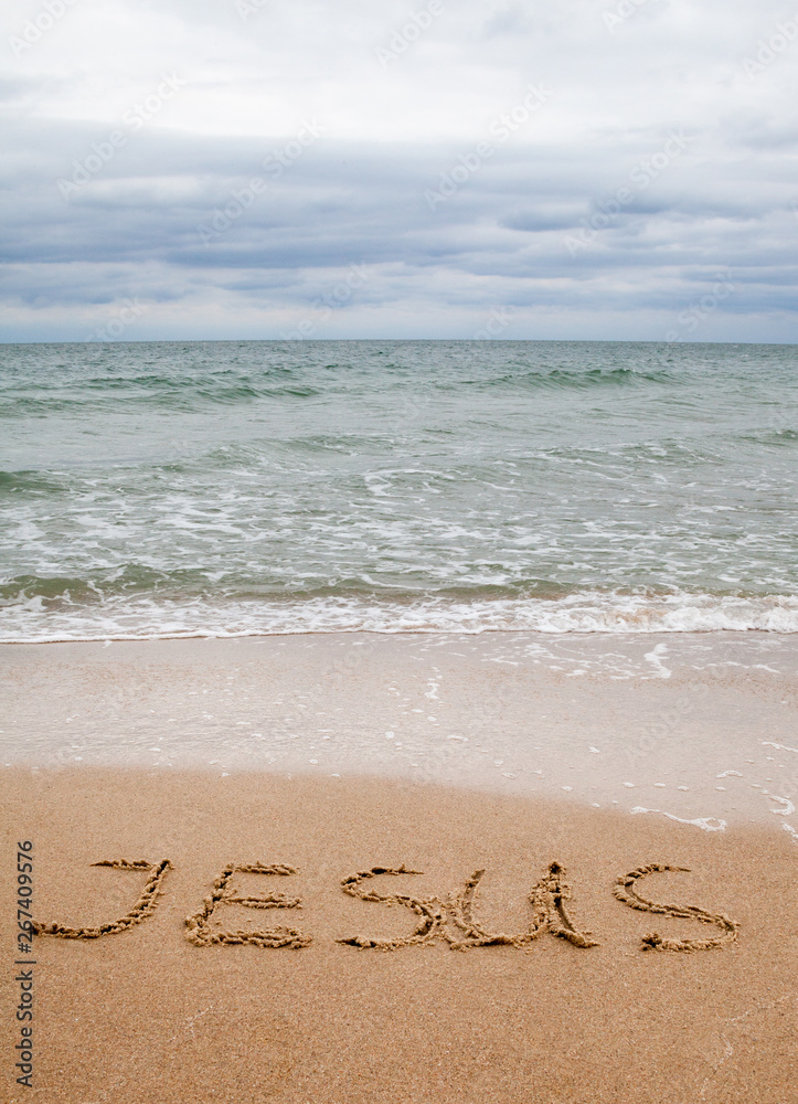 Fototapeta premium Word Jesus written on the sand