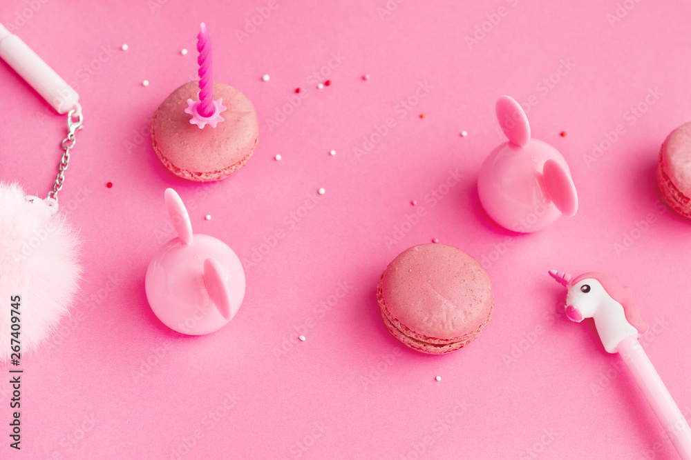School stationery with unicorn pen,fur, macaroons on a pink background. Back to school creative table desk.  Minimal food bakery concept. Flat lay top view with copy space -