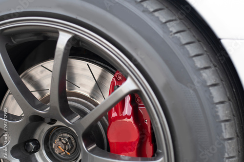 Close up image of racing sport car's wheel with red break bumper and dish.