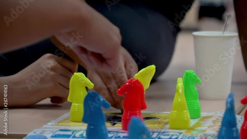 Hands playing board game. Children play Seahorse board game together