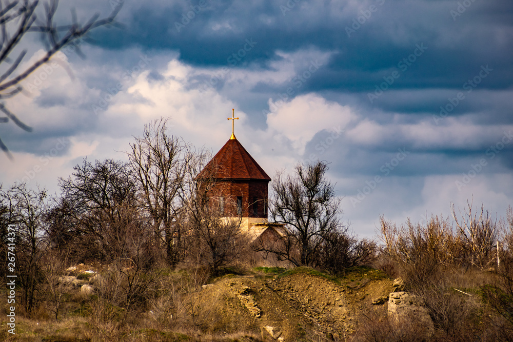 New unfinished Church among the vegetation and dry grass, in the spring with a blue cloudy sky. Dome with cross at the top. Interesting and unusual landscape in the Rostov region New unfinished Church among the vegetation and dry grass, in the spring with a blue cloudy sky. Dome with cross at the top. Interesting and unusual landscape in the Rostov region