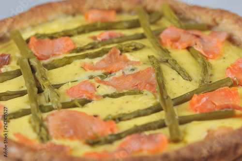 Traditional cake quiche with asparagus and red fish close-up. View from above.