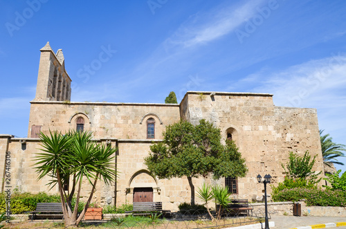 Ancient building of Bellapais Abbey in small Cypriot city Bellapais in Turkish part of Cyprus with blue sky above. The ruin of a monastery from 13th century is a popular tourist attraction