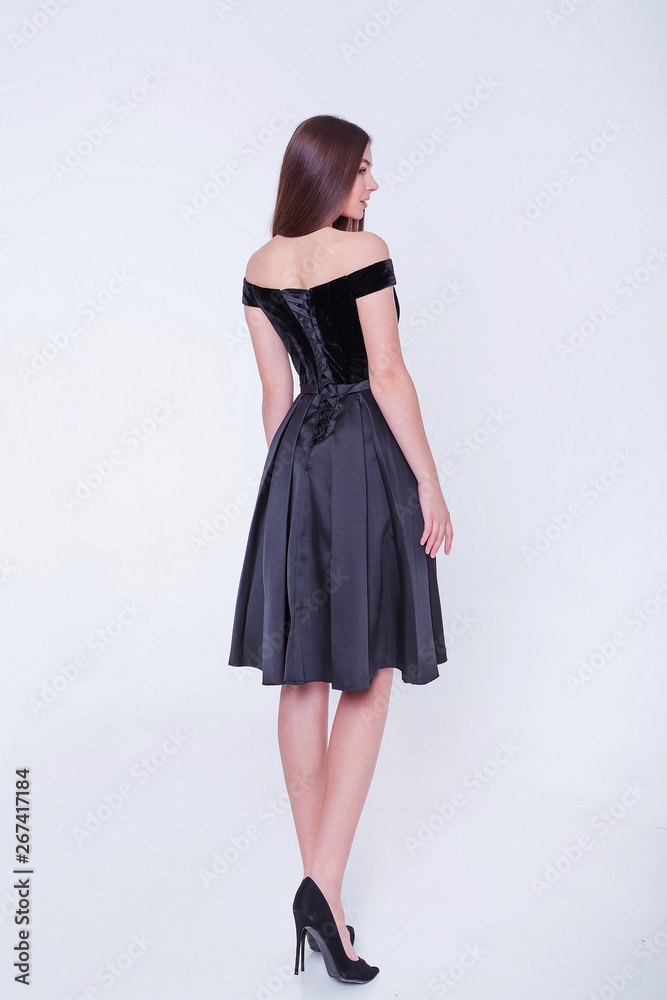 Fototapeta premium Beauty brunette model woman in cocktail dress. Beautiful fashion luxury makeup and hairstyle. Seductive girl silhouette on white background.