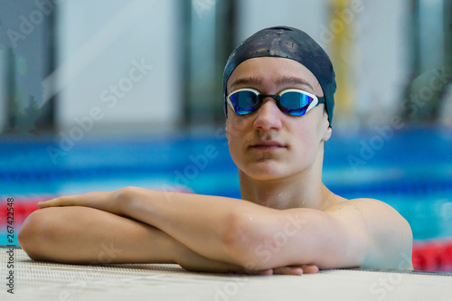 Portrait of athletic teenage boy at the sports pool.
