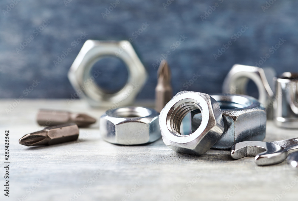 Hex nuts and bits for a screwdriveron wooden background. Close up. Copy space. Hex nuts and bits for a screwdriveron wooden background. Close up. Copy space.
