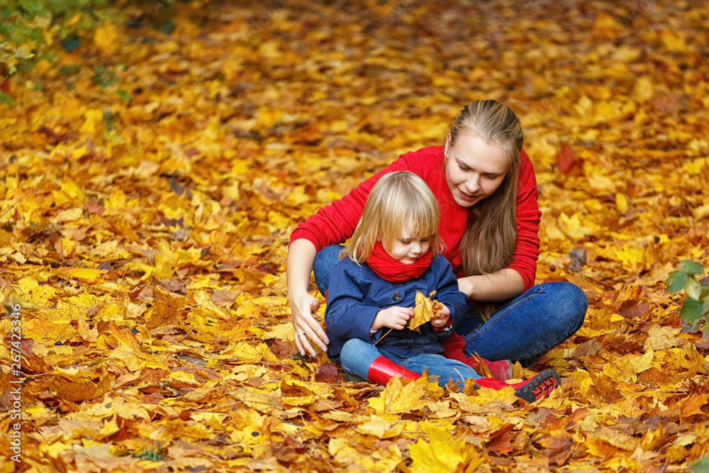 Happy autumn. A mother and daughter are playing and laughing in an autumn park. Happy autumn. A mother and daughter are playing and laughing in an autumn park.
