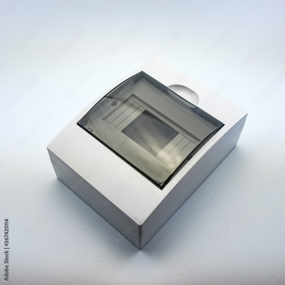 Plastic gray plastic electrical installation junction box on a white background. Electric switchboard on the white wall of a factory.