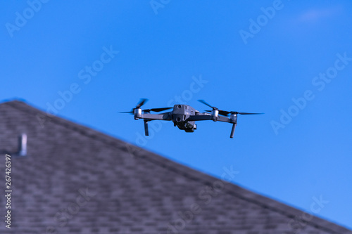 Camera drone hovering near neighborhood house