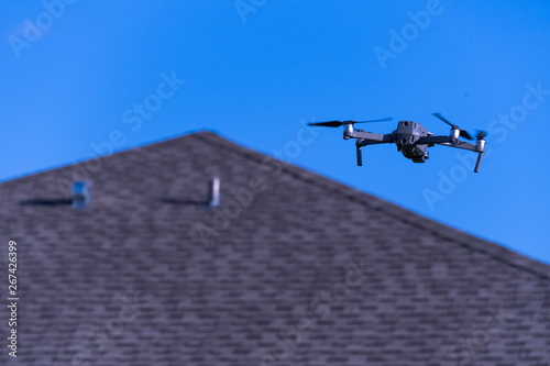 Camera drone hovering near neighborhood house