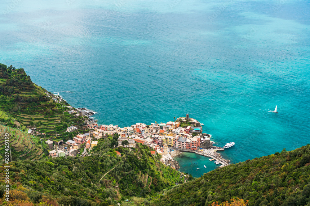 Amazing view over the colorful town of Vernazza in Cinque Terre, Italy, as seen from the hiking trail passing above it. Landscape of a coastal fishing village at the Ligurian Sea.