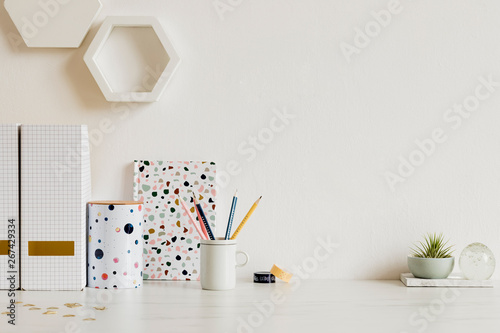 Modern and stylish home interior with elegant office accessories, notes, memo sticks, pencils, air plants and elegant binder. Scandinavian home decor. Minimalistic concept. Template. Copy space.