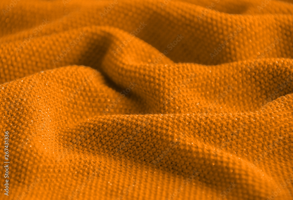 The texture of a knitted woolen fabric orange. The texture of a knitted woolen fabric orange.