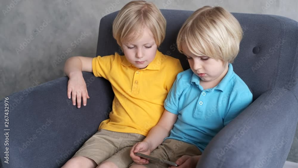 Brothers are watching or playing or learning something in a smartphone Brothers are watching or playing or learning something in a smartphone