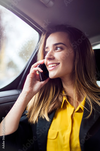 Young businesswoman talking on mobile phone in car