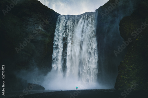 Hiker at gigantic Skogafoss waterfall in Iceland photo