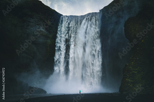 Canvas Print Hiker at gigantic Skogafoss waterfall in Iceland