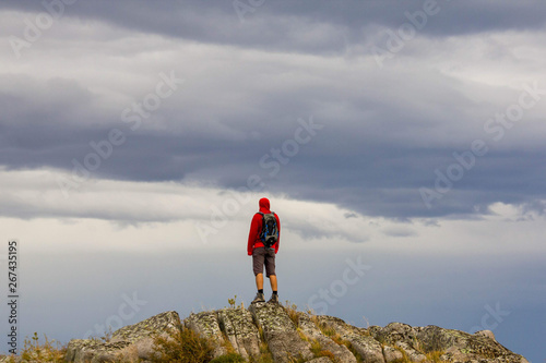A man stays at the mountain with his back