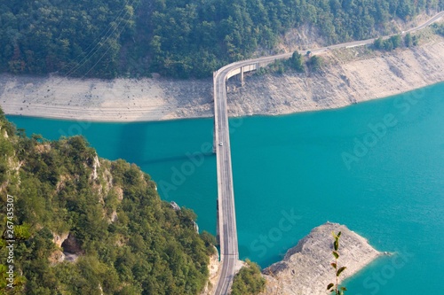 Fantastic view on canyon of river Piva (Pivsko jezero) with beautyful turquoise water and bridge across the river in the summer evening, Montenegro photo