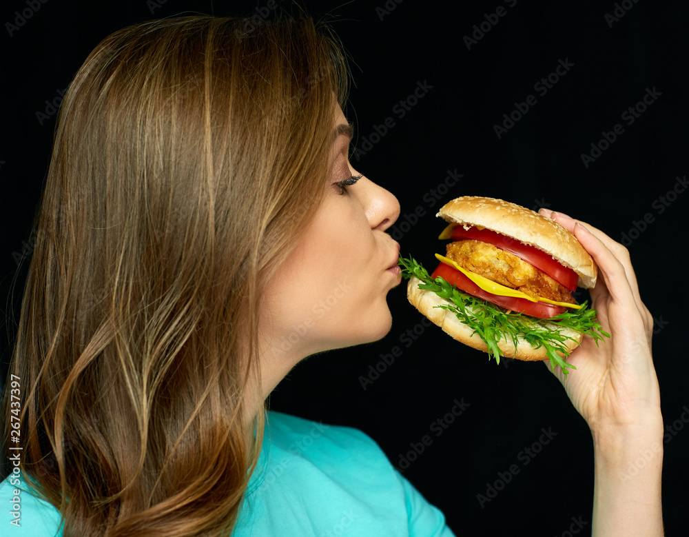 happy woman holding burger on black background. happy woman holding burger on black background.