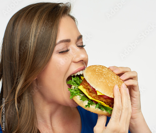 portrait of woman biting burger.