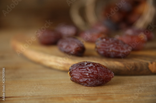 royal dates on a wooden board, wooden natural background, closeup. Healthy food.